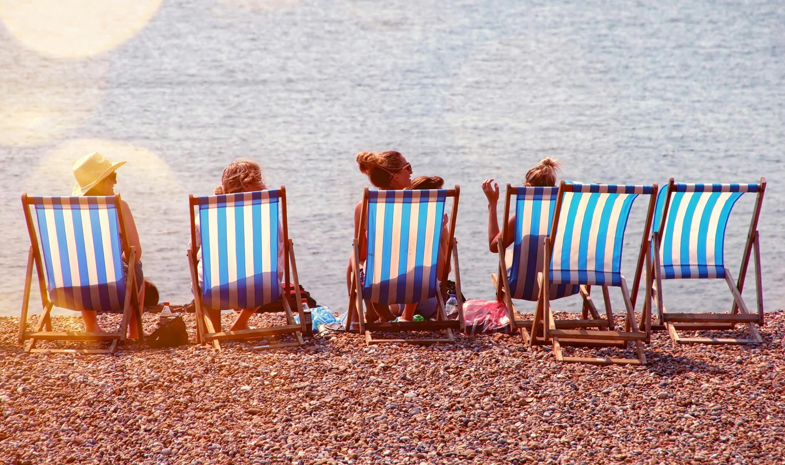 femme profitant de leur jour férié assises sur des chaises longues face à la mer